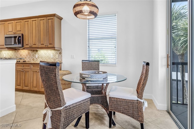 dining space featuring light tile patterned floors and baseboards