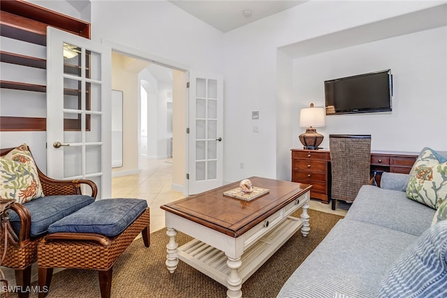 living room featuring light tile patterned floors, french doors, and arched walkways