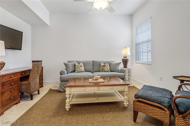 living area featuring a ceiling fan and baseboards