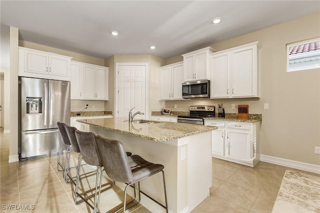 kitchen featuring white cabinetry, sink, appliances with stainless steel finishes, and an island with sink