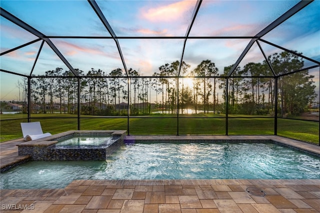 pool at dusk featuring a lanai, an in ground hot tub, a lawn, and pool water feature