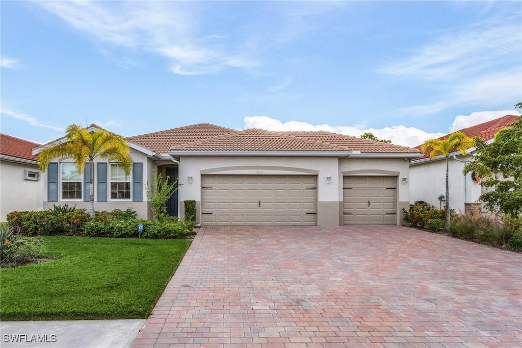 mediterranean / spanish-style home with a front yard and a garage