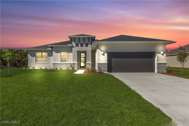 prairie-style home featuring a yard and a garage