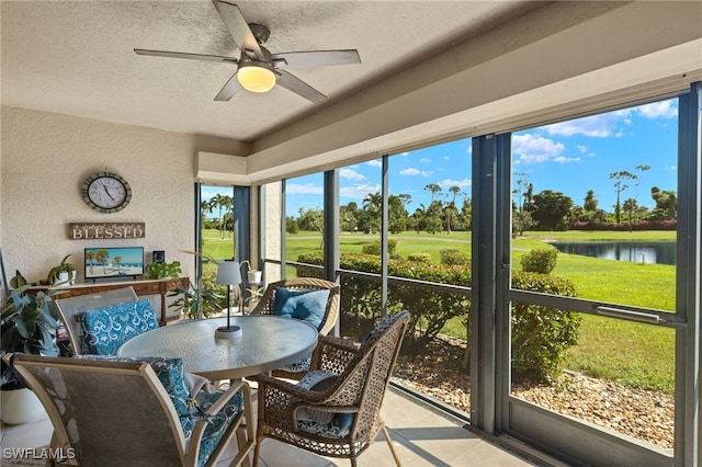 sunroom featuring ceiling fan, plenty of natural light, and a water view