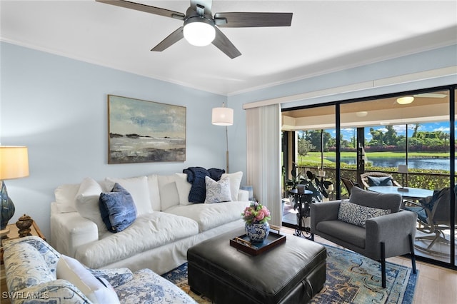 living room with ornamental molding, a water view, ceiling fan, and hardwood / wood-style floors