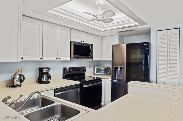 kitchen with sink, white cabinets, stainless steel appliances, a raised ceiling, and ceiling fan