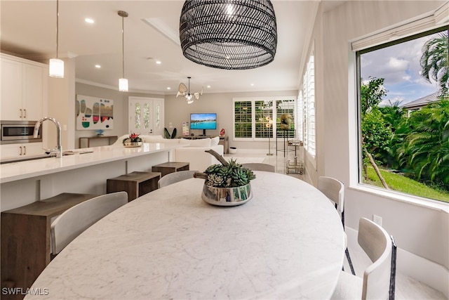 dining space featuring crown molding, a healthy amount of sunlight, and a chandelier