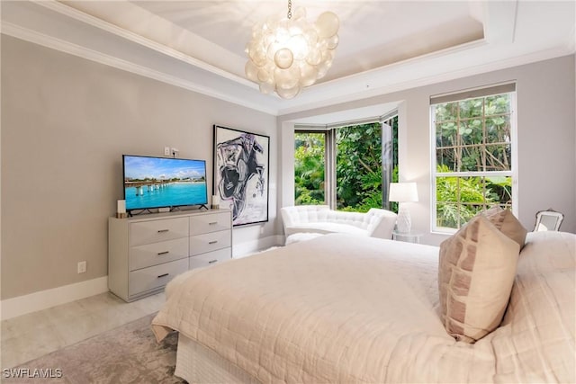 bedroom featuring baseboards, a chandelier, a raised ceiling, and crown molding