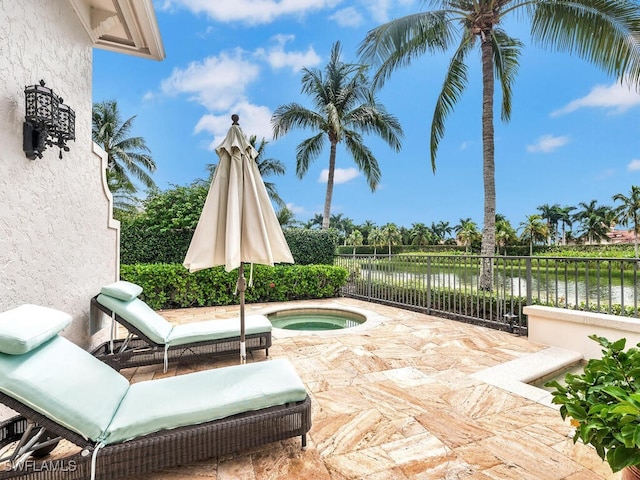 view of patio with an in ground hot tub and a water view