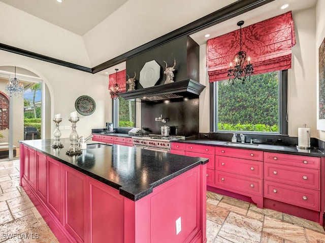 kitchen with stainless steel stove, vaulted ceiling, a chandelier, sink, and a kitchen island