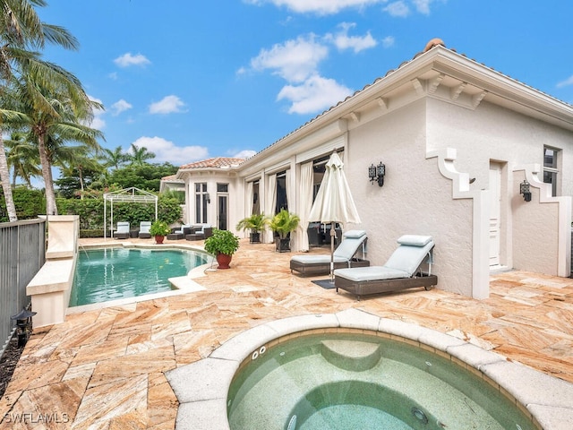 view of swimming pool with a patio area, pool water feature, and an in ground hot tub