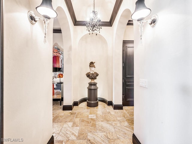 hallway featuring crown molding and a notable chandelier