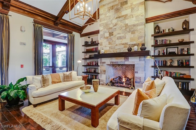 living room with dark hardwood / wood-style flooring, a stone fireplace, and a chandelier