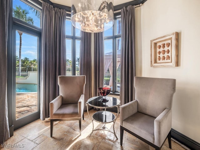 living area featuring plenty of natural light and a notable chandelier