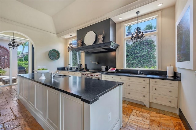 18281 Via Caprini Dr, Miromar Lakes, FL 33913 - kitchen with a chandelier, stone tile floors, dark countertops, plenty of natural light, and recessed lighting