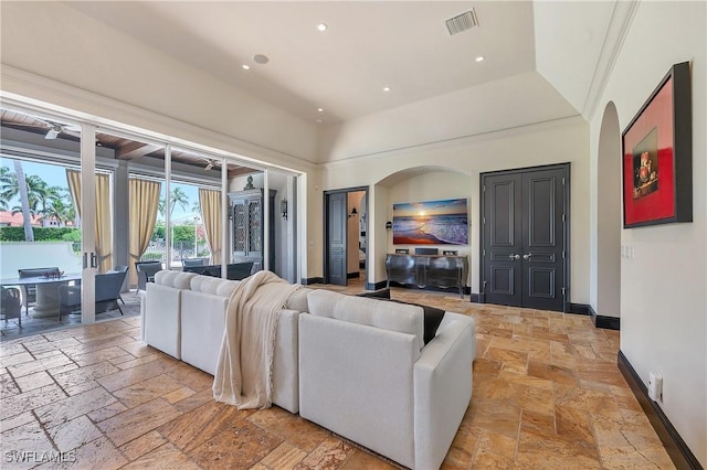 18281 Via Caprini Dr, Miromar Lakes, FL 33913 - living room with arched walkways, stone tile flooring, and recessed lighting