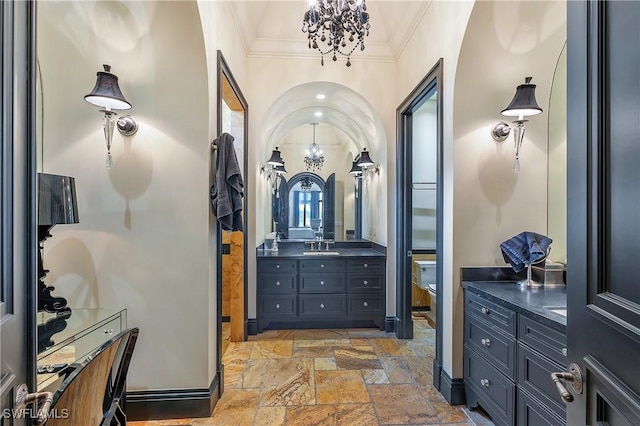 18281 Via Caprini Dr, Miromar Lakes, FL 33913 - bathroom with a chandelier, stone tile floors, crown molding, and vanity