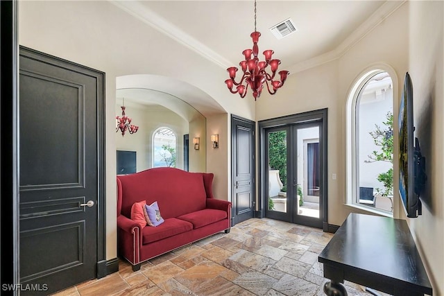 18281 Via Caprini Dr, Miromar Lakes, FL 33913 - entrance foyer featuring a chandelier, crown molding, arched walkways, and stone tile flooring