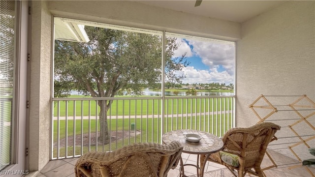 sunroom featuring a water view