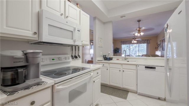 kitchen with white appliances, white cabinetry, a sink, and light countertops