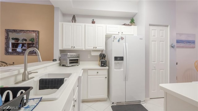 kitchen with a sink, white cabinets, white refrigerator with ice dispenser, and a toaster