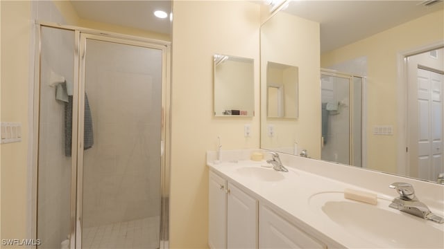 bathroom with vanity and a shower with door