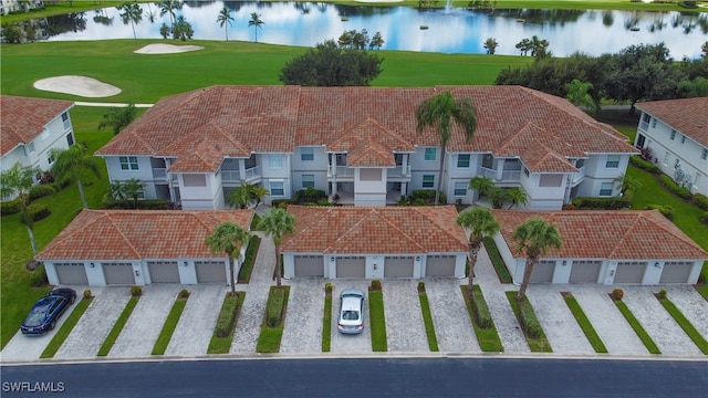 view of front of home with a water view, a garage, and a balcony