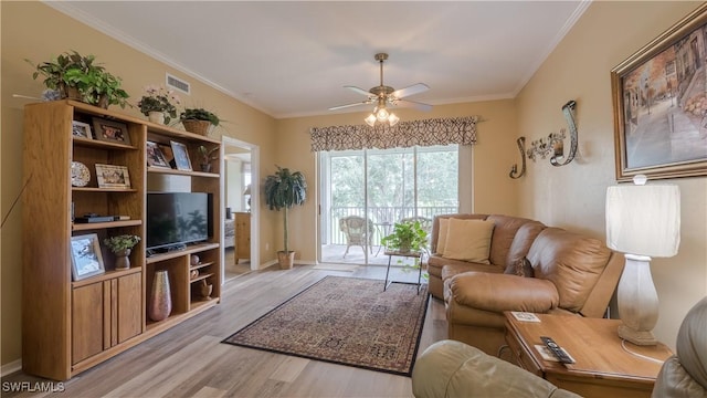 living area featuring crown molding, visible vents, baseboards, ceiling fan, and light wood-type flooring