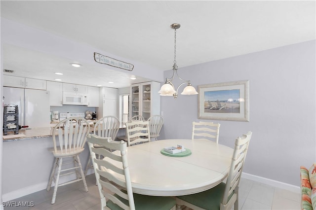 dining space featuring light tile patterned floors and a chandelier