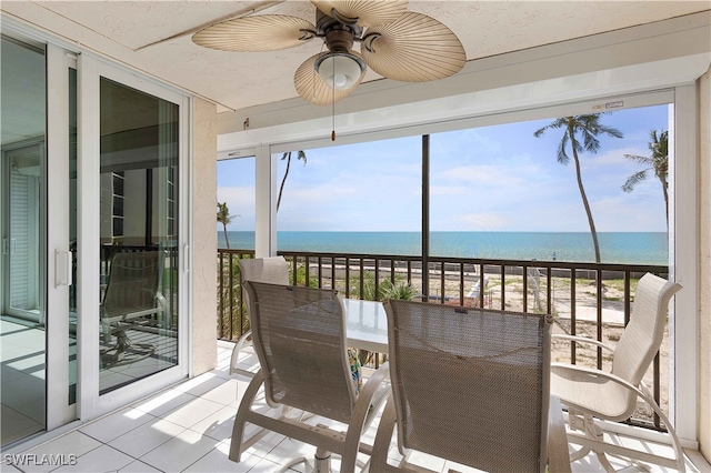 balcony featuring a water view and ceiling fan