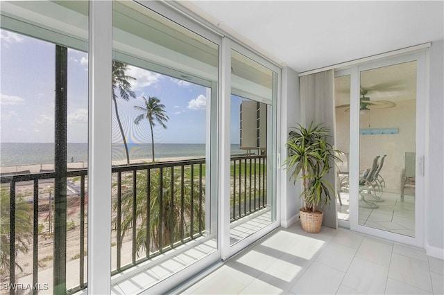 doorway featuring plenty of natural light, ceiling fan, and a water view