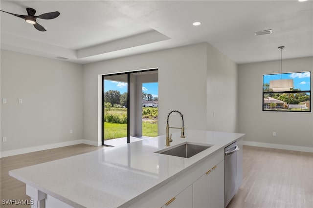 kitchen with light stone countertops, light hardwood / wood-style floors, sink, ceiling fan, and white cabinets