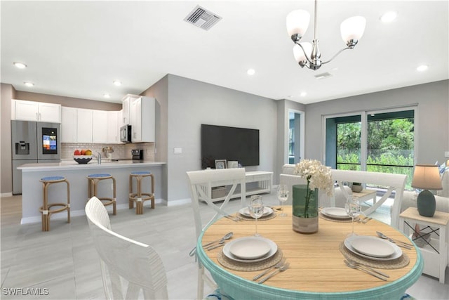 tiled dining area featuring an inviting chandelier