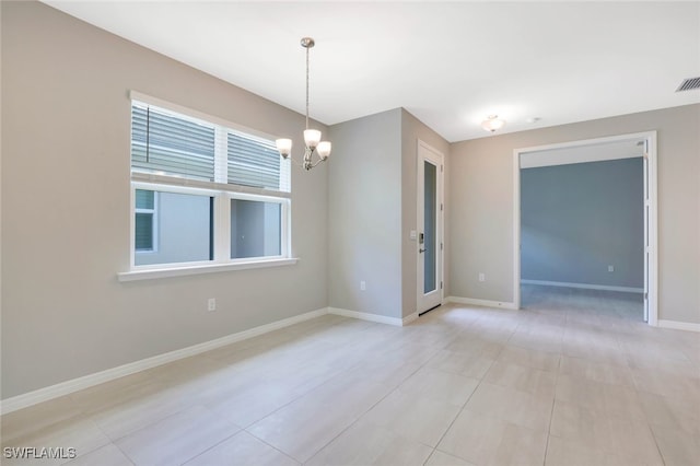 tiled empty room with a chandelier