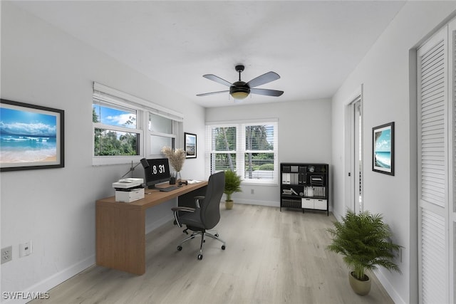 home office with light wood finished floors, baseboards, and a ceiling fan