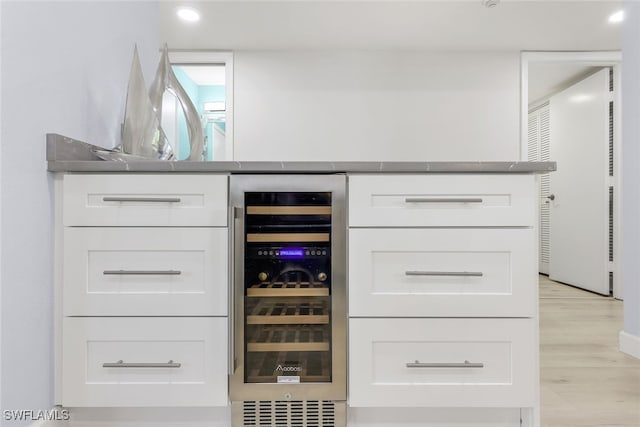 bar with light wood-type flooring, beverage cooler, a dry bar, and recessed lighting