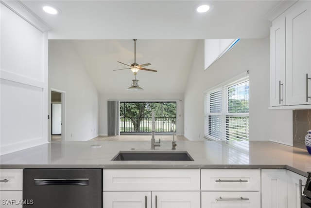 kitchen featuring dark countertops, white cabinetry, a sink, and dishwashing machine