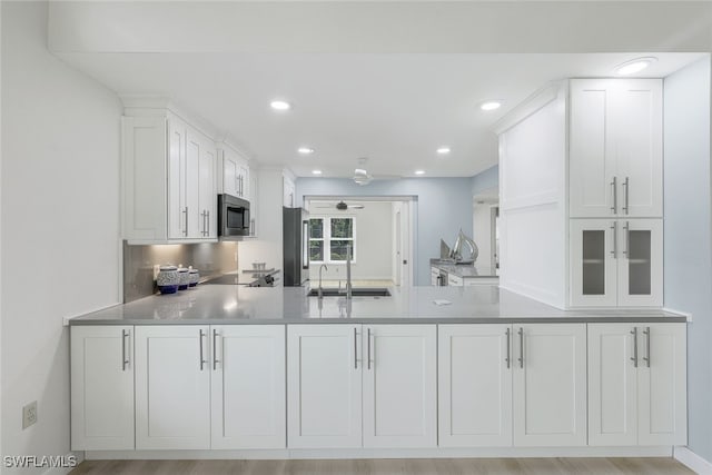 kitchen with ceiling fan, a sink, white cabinetry, light countertops, and appliances with stainless steel finishes