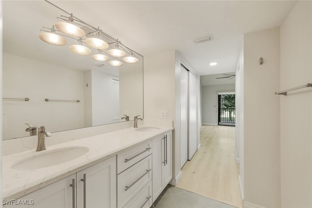 full bath with double vanity, tile patterned flooring, baseboards, and a sink