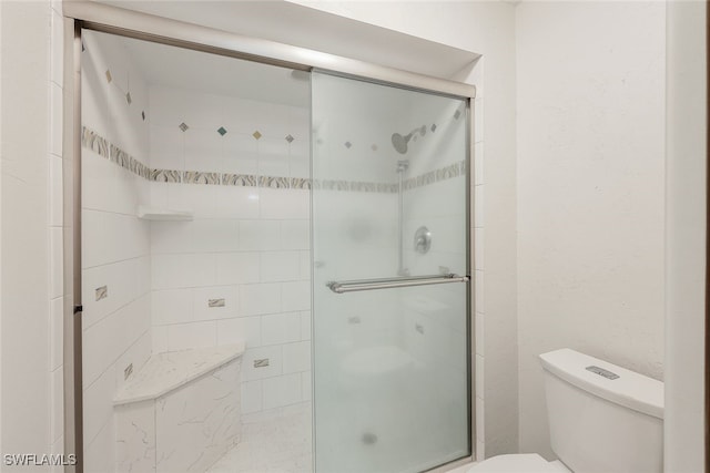 bathroom featuring toilet and a stall shower