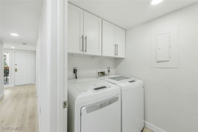 washroom featuring washing machine and dryer, baseboards, cabinet space, electric panel, and light wood finished floors