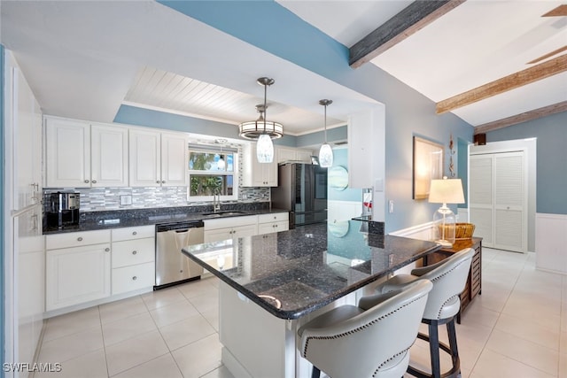 kitchen featuring pendant lighting, a kitchen breakfast bar, beam ceiling, stainless steel dishwasher, and black fridge