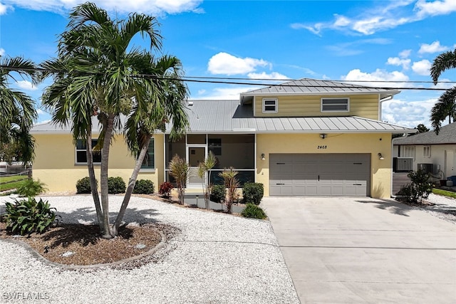 view of front of property featuring a garage and central AC unit