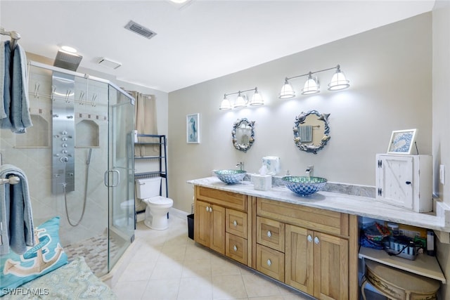 bathroom featuring vanity, toilet, an enclosed shower, and tile patterned flooring