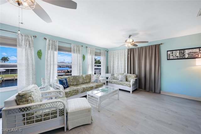 living room with light hardwood / wood-style flooring and ceiling fan