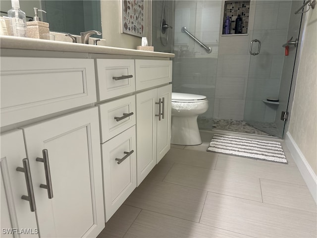 bathroom featuring tile patterned flooring, toilet, a shower with door, and vanity