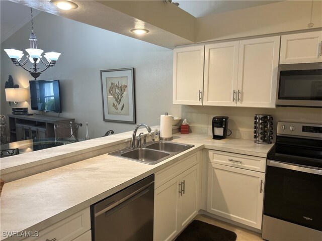 kitchen featuring hanging light fixtures, appliances with stainless steel finishes, white cabinetry, a notable chandelier, and sink