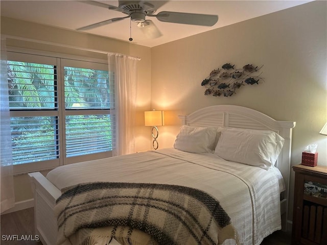 bedroom featuring baseboards, a ceiling fan, and dark wood-style flooring