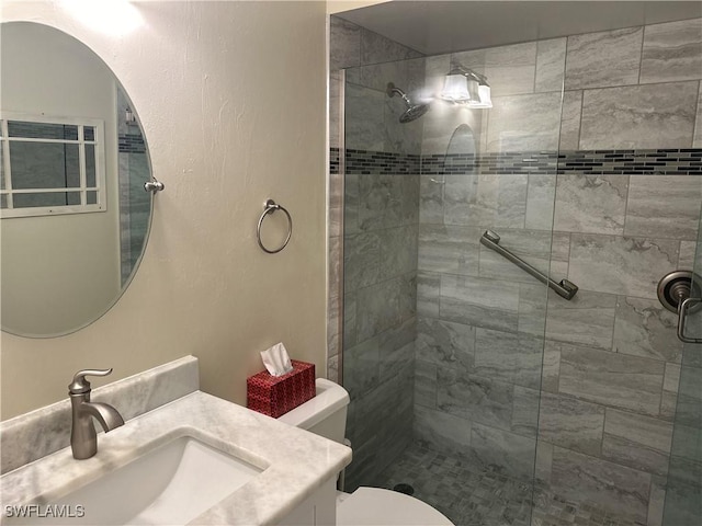 full bathroom featuring toilet, a tile shower, and vanity