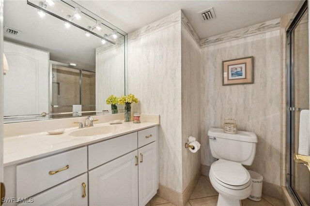 bathroom with vanity, walk in shower, tile patterned floors, and toilet